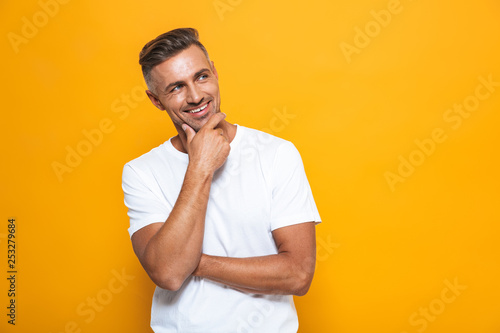 Handsome happy excited man posing isolated over yellow wall background.