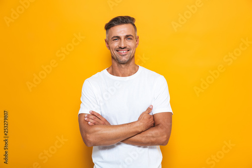 Handsome happy excited man posing isolated over yellow wall background.