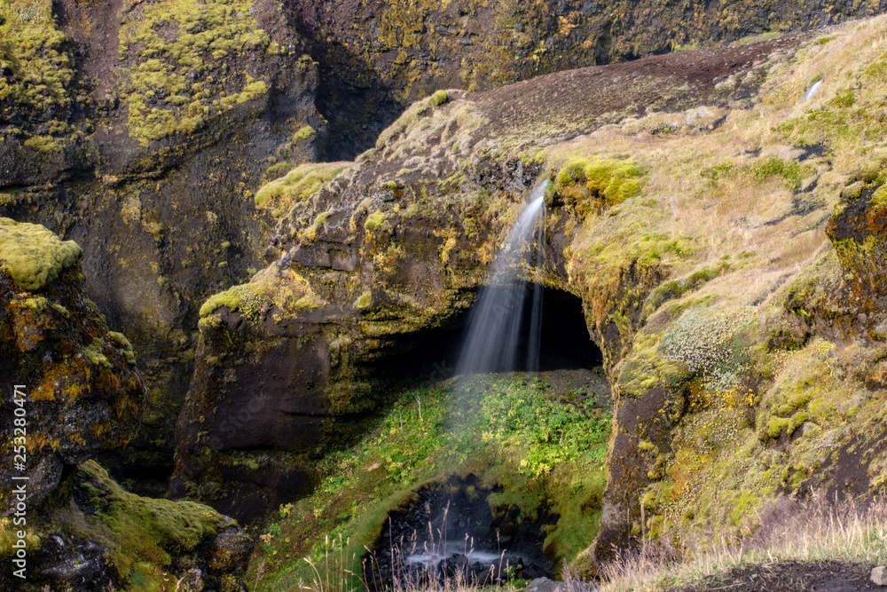 View of a waterfall in Iceland. Water flows from top to bottom. View of a waterfall in Iceland. Water flows from top to bottom.