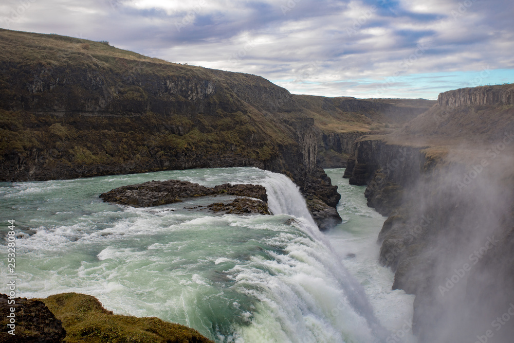 View of a waterfall in Iceland. Water flows from top to bottom. View of a waterfall in Iceland. Water flows from top to bottom.