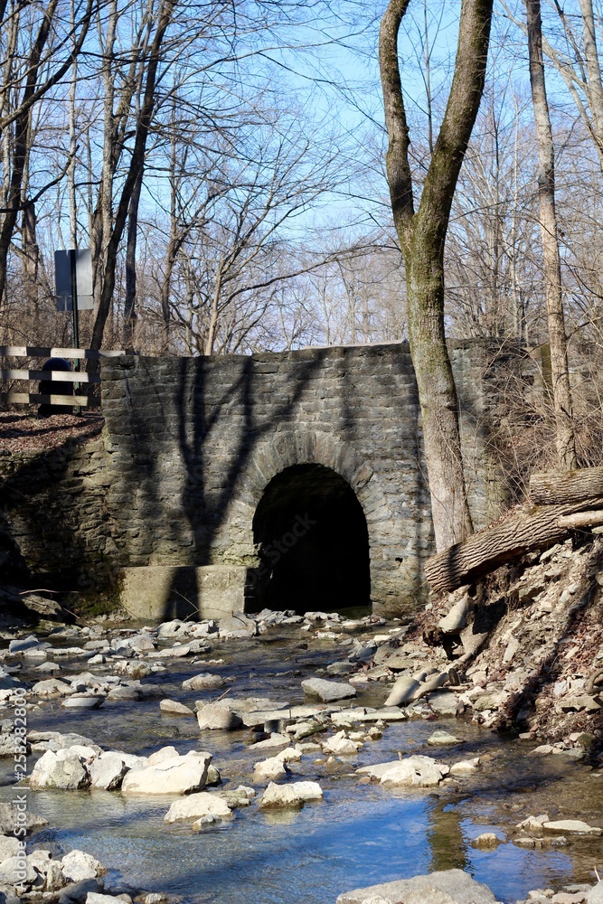 The old stone bridge over the flowing creek water.