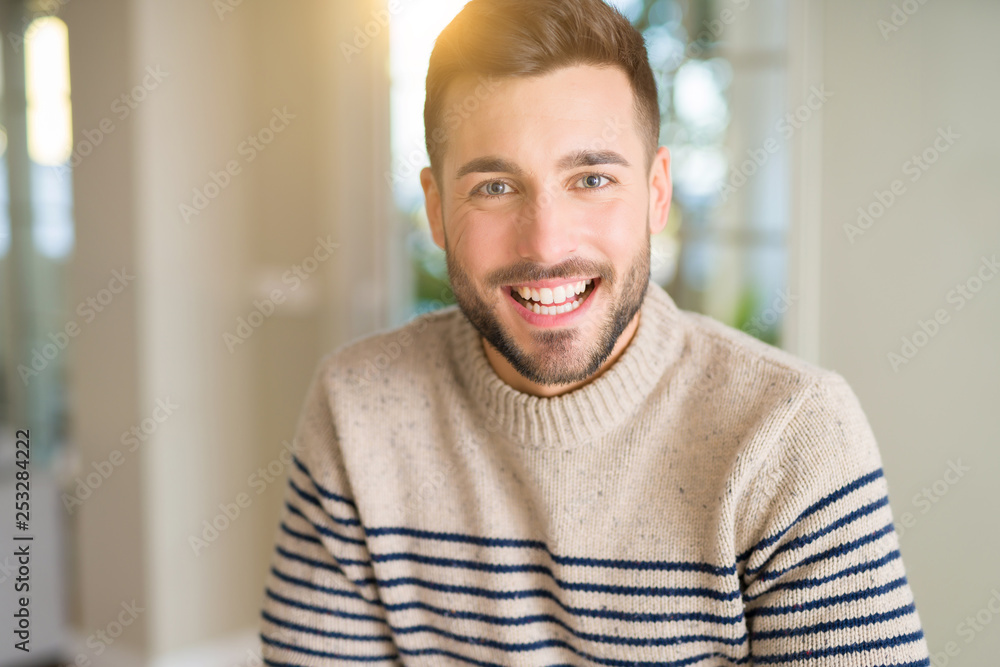 Young handsome man at home with a happy face standing and smiling with a confident smile showing teeth Young handsome man at home with a happy face standing and smiling with a confident smile showing teeth