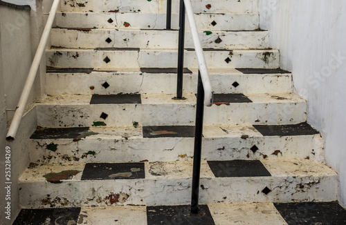 Weathered old black and white painted steps in a walkway image with copy space in landscape format photo