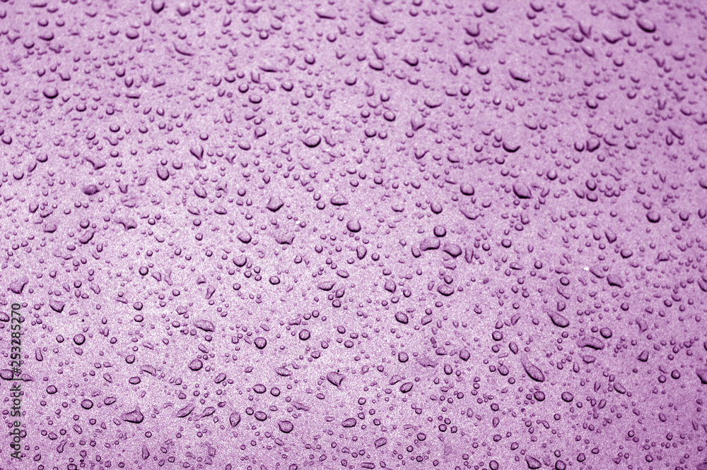 Water drops on car surface in purple tone. Water drops on car surface in purple tone.