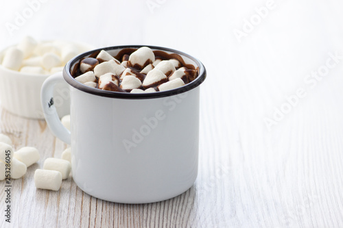 Hot chocolate with marshmallows in a white metal vintage mug