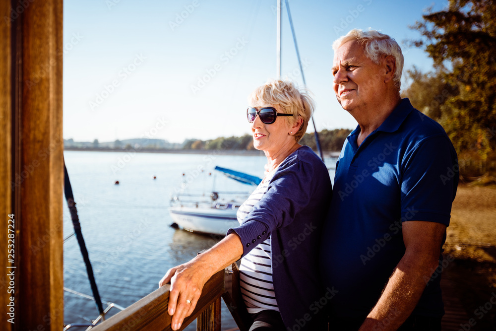 Confident elderly couple at harbor on sunny day