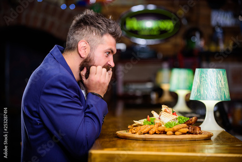 Enjoy meal. High calorie snack. Cheat meal concept. Hipster hungry eat pub fried food. Manager formal suit sit at bar counter. Delicious meal. Man received meal with fried potato fish sticks meat