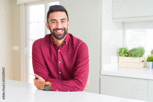 Handsome hispanic business man happy face smiling with crossed arms looking at the camera. Positive person.