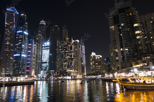 Illuminated skyscrapers from Dubai Marina reflected in water during the night