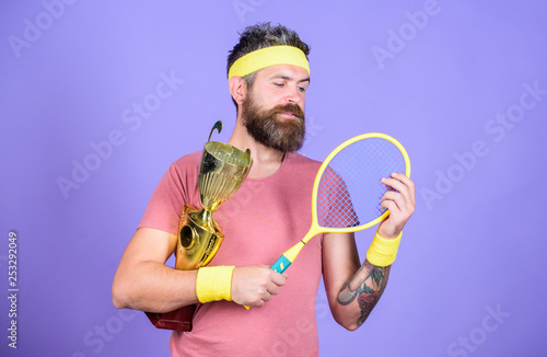 Athlete hold tennis racket and golden goblet. Win tennis game. Man bearded hipster wear sport outfit. Success and achievement. Tennis match winner. Achieved top. Tennis player win championship © be free