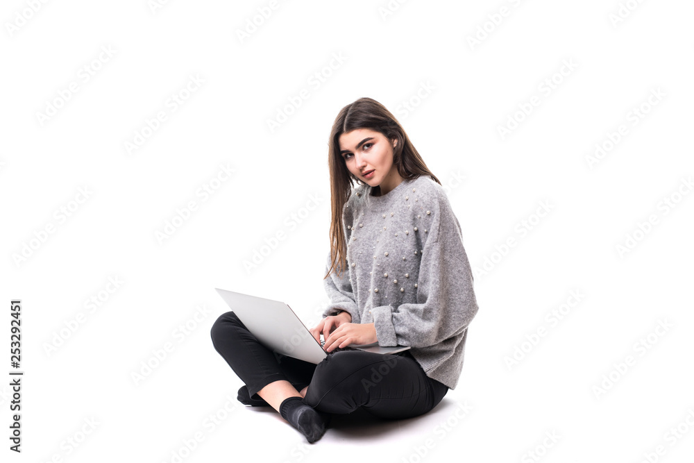 Portrait of woman in casual sitting on floor in lotus pose and holding laptop isolated over white background Portrait of woman in casual sitting on floor in lotus pose and holding laptop isolated over white background