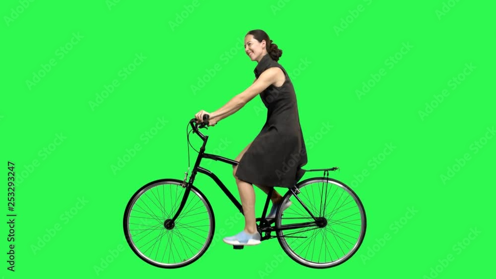 A Cute woman riding a bicycle over a green screen, looking around., waving hello. No motion blur for optimal keying. A Cute woman riding a bicycle over a green screen, looking around., waving hello. No motion blur for optimal keying.
