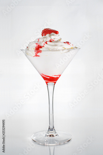 ice cream in a glass with raspberry jam and strawberries