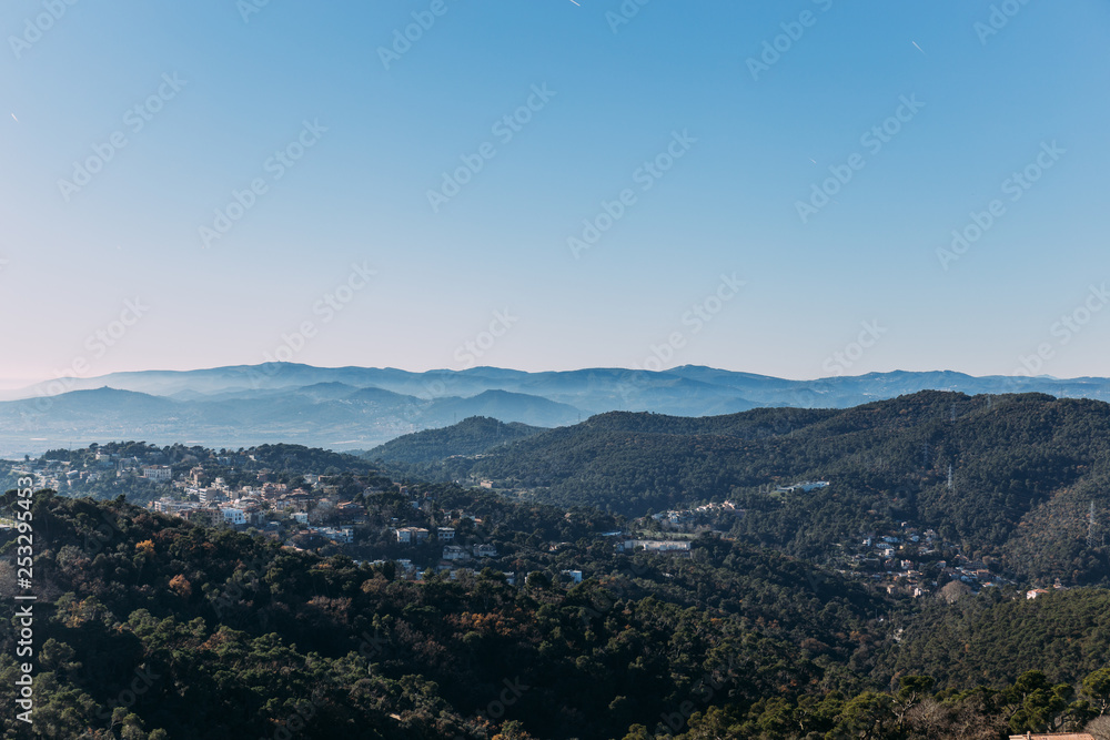aerial view of city on green hills with skyline, barcelona, spain