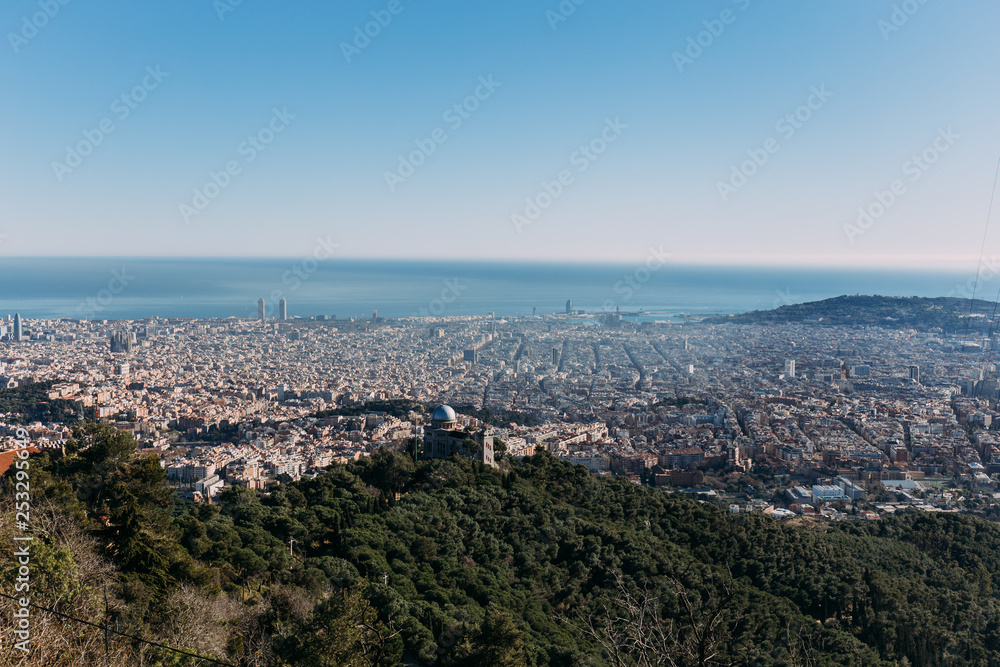 aerial view of city at foot of green hills, barcelona, spain