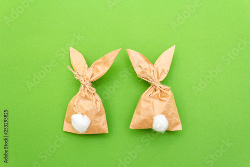 Easter bunny paper gift egg wrapping DIY idea on colorful background. Minimal easter concept, flat lay, close up.