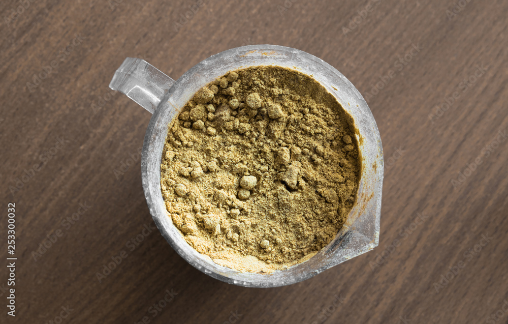 Measuring cup with brown powder Measuring cup with brown powder