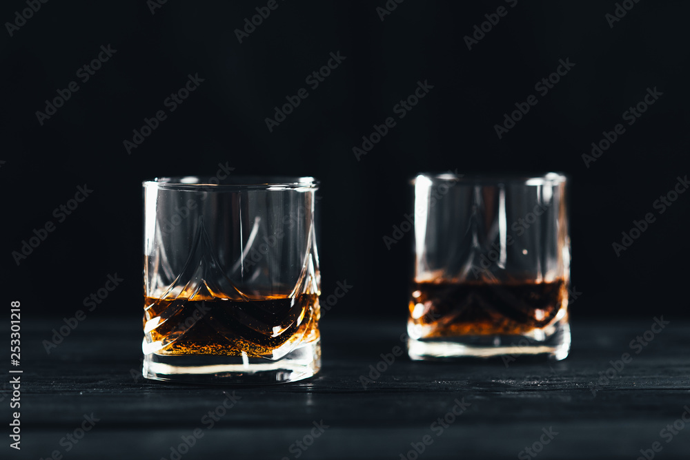 Two glasses with ice and whiskey on wooden background Two glasses with ice and whiskey on wooden background