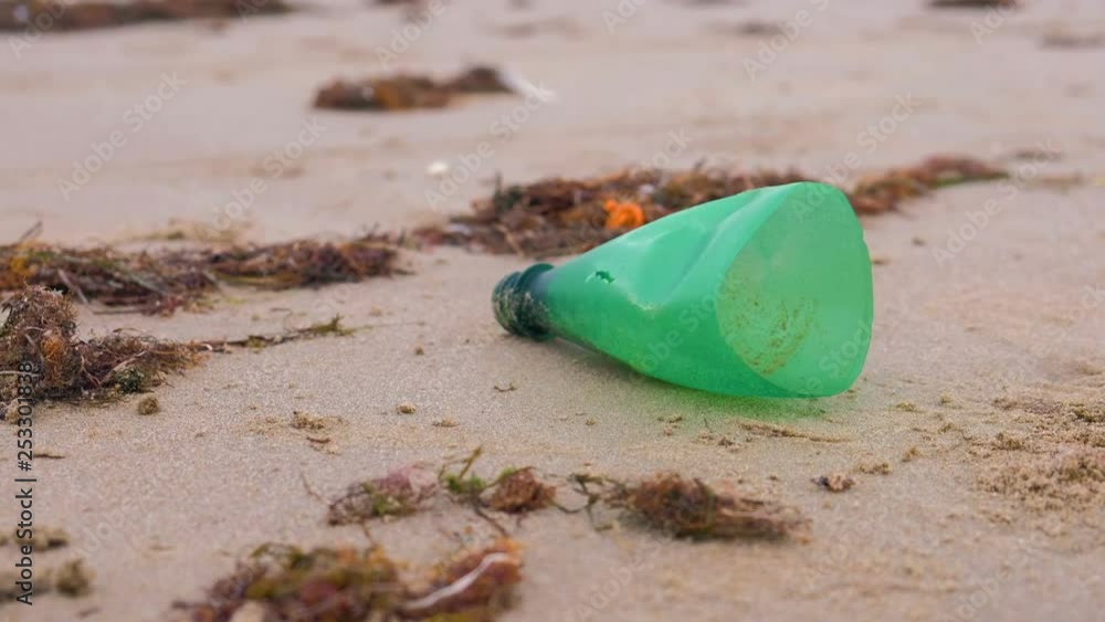 Part of plastic bottle was brought to the shore on the sandy shore. Part of plastic bottle was brought to the shore on the sandy shore.