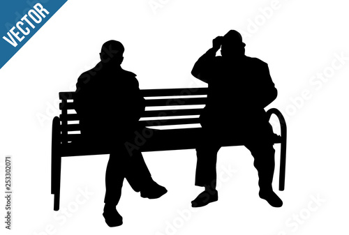 Two elderly people silhouettes sitting on a park bench
