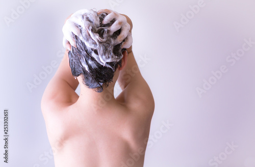 A sexy woman washing her hair in the shower.