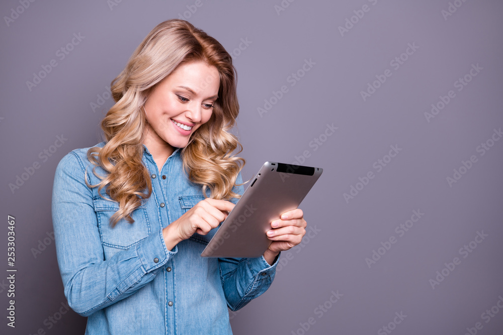 Portrait of her she nice cute lovely charming attractive cheerful cheery wavy-haired lady wearing blue shirt holding in hands new cool tablet isolated over gray pastel background