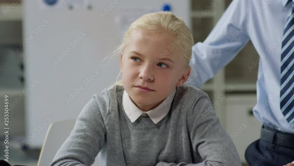 Pan shot of Caucasian girl sitting at table and talking to her male classmates sitting near her Pan shot of Caucasian girl sitting at table and talking to her male classmates sitting near her