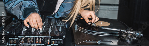 Obraz na płótnie panoramic shot of dj woman standing near dj mixer and vinyl record