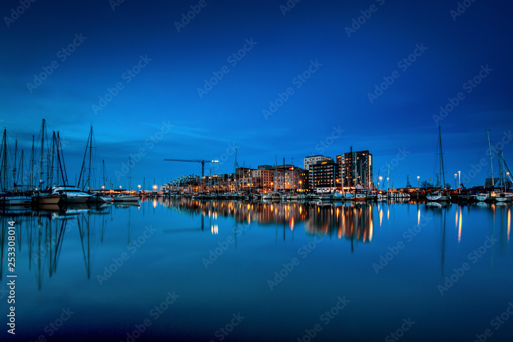 Fototapeta Aarhus Ø seen at night time with water reflections and Aarhus Marina in the foreground