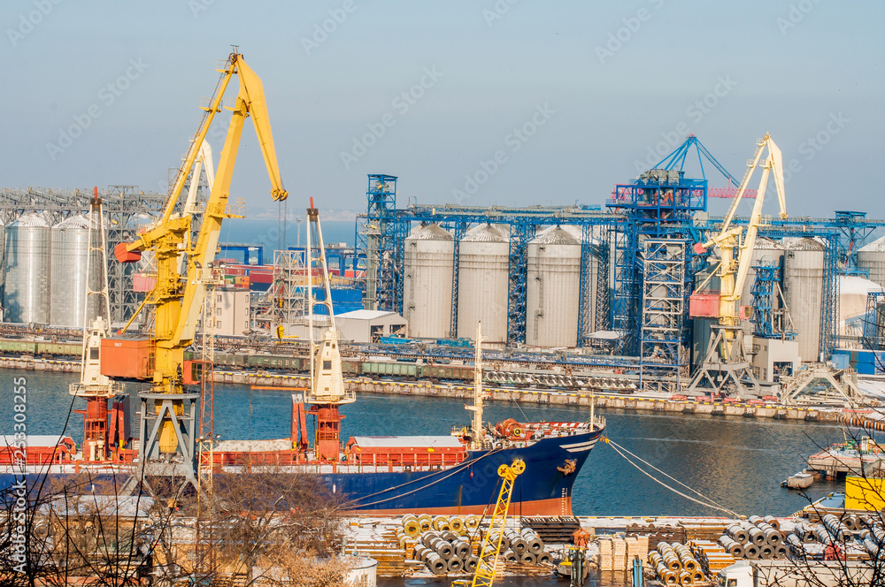 Logistics and transportation of a container cargo ship with a working crane at the shipyard, logistics export and transport industry.