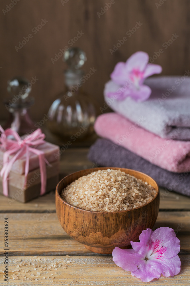 Sea salt, natural handmade soap, natural cosmetic oil and colorful towels with azalea flowers on rustic wooden background Sea salt, natural handmade soap, natural cosmetic oil and colorful towels with azalea flowers on rustic wooden background