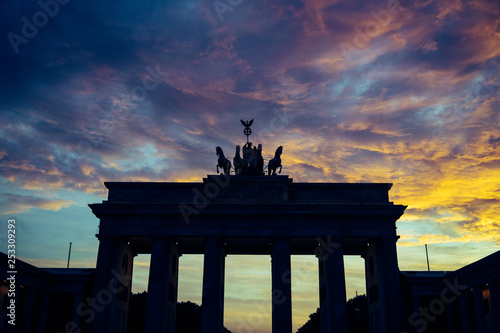 Silhouette de la porte de Brandebourg dans la ville de Berlin, le ciel est nuageux de couleur bleu et jaune, c'est le couché de soleil.
