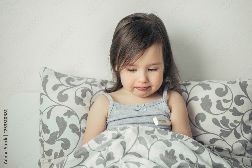 The little girl caught a cold. The girl lies in bed and is ill. The