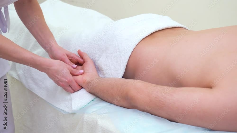 female hands doing relaxing massage on palm of male customer in spa salon female hands doing relaxing massage on palm of male customer in spa salon
