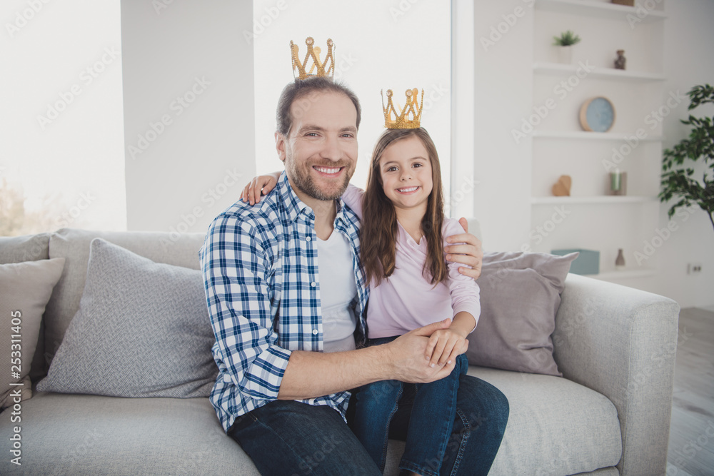 Portrait of his he her she nice cute lovely attractive cheerful cheery positive pre-teen girl bearded dad daddy sitting on divan in light white interior room indoors