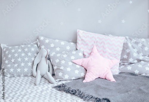 Modern baby bed with gray pillows. Close-up