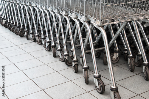 Rows of Metal Shopping Trollies outside shop ready for shoppers to use.