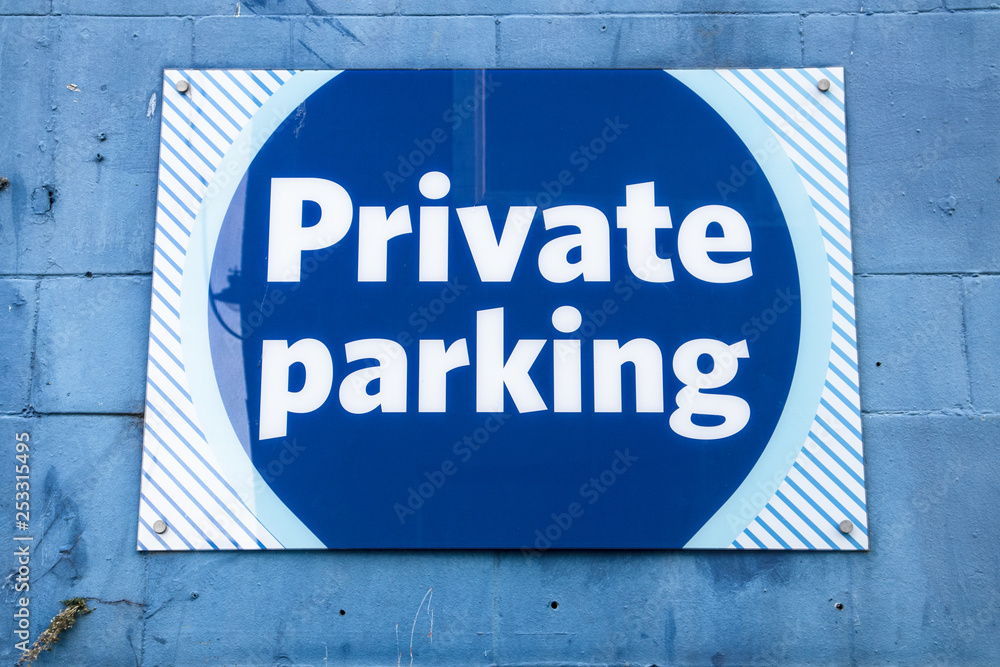 Private Parking sign in blue and white on a painted blue brick wall Private Parking sign in blue and white on a painted blue brick wall