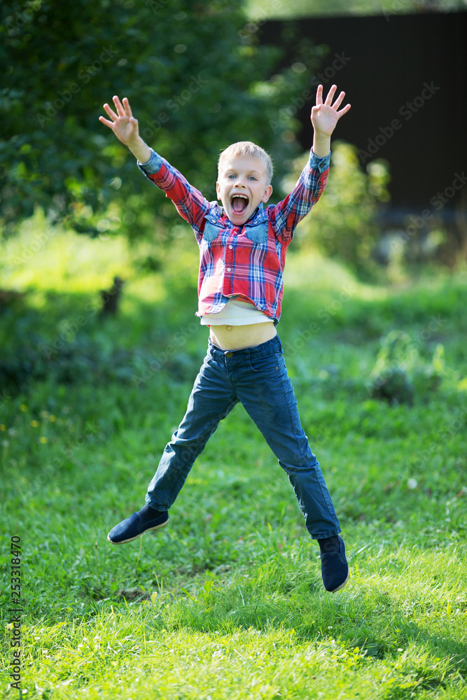 little boy joyfully jumping in the summer in the garden little boy joyfully jumping in the summer in the garden