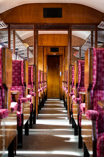 Colchester / Great Britain - May 12, 2013: Interior shot of vintage railway carriage showing seating, ilse wooden trimmings and lugage rack. photo