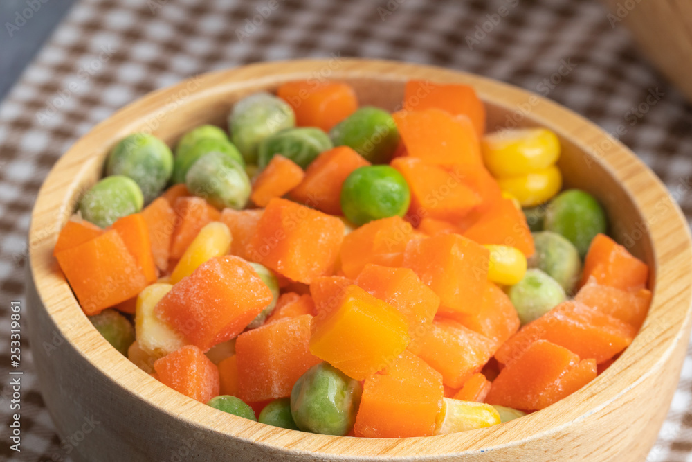 carrots corns and peas on wooden bowl carrots corns and peas on wooden bowl