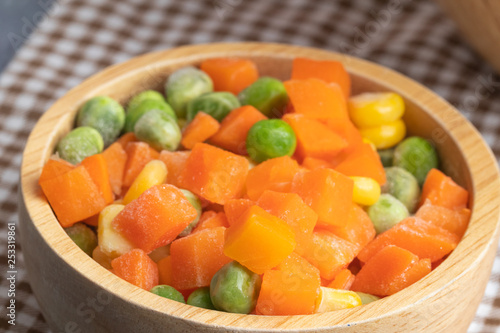 carrots corns and peas on wooden bowl