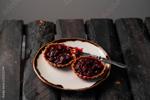 cherry tartlets on dark wooden backdrop, rustic style