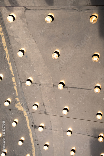 Reflection in mirrored ceiling illuminated by light bulbs at theatre entrance