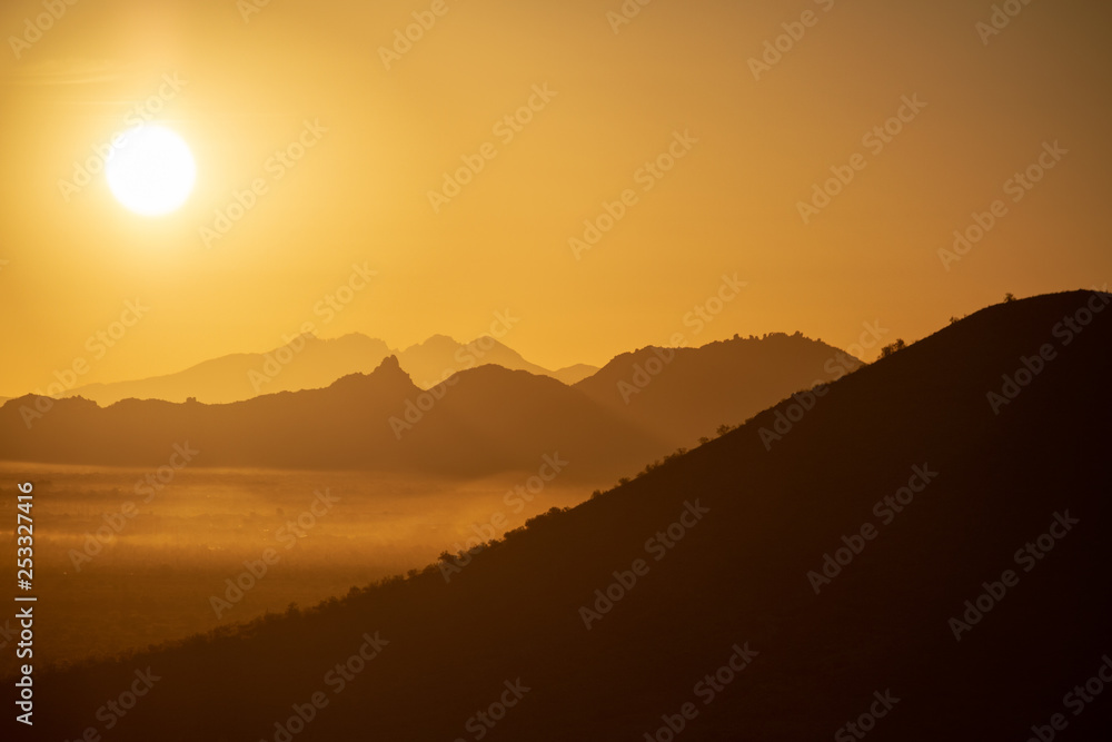 The sun rising over the mountains of the Arizona desert with natural warm hues. The sun rising over the mountains of the Arizona desert with natural warm hues.