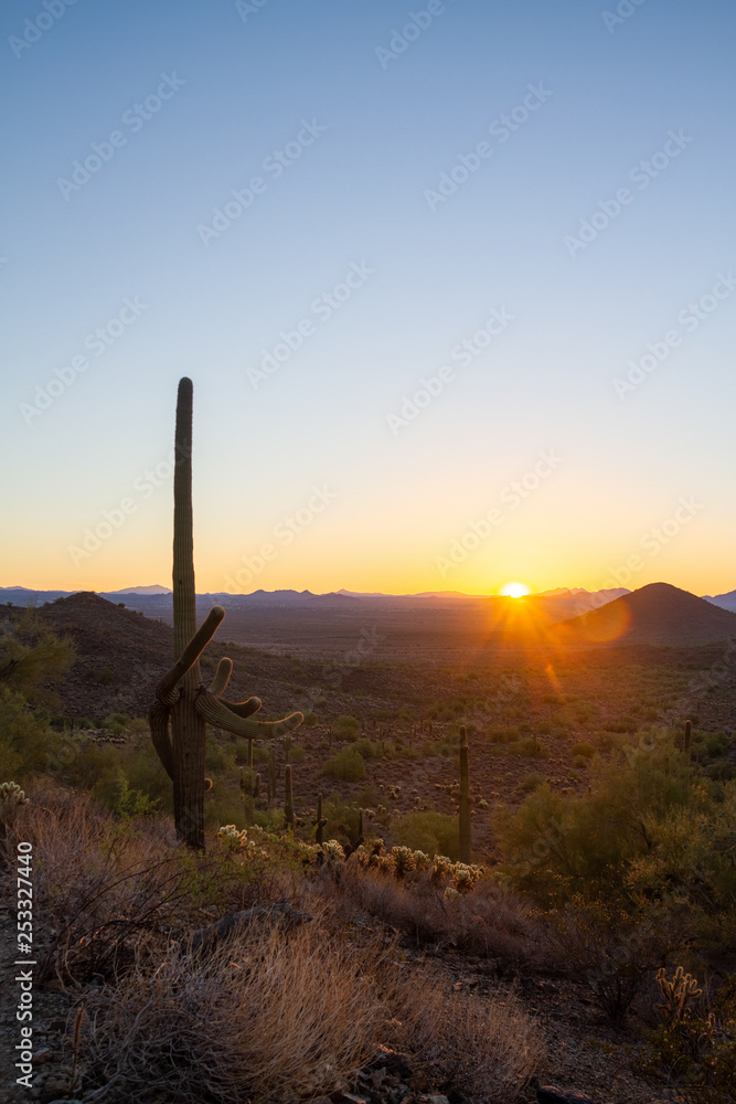 The sun rising above the Arizona Desert with the Four Peaks in the distant background and a clear blue sky. The sun rising above the Arizona Desert with the Four Peaks in the distant background and a clear blue sky.
