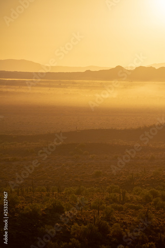 The sun rising over the mountains of the Arizona desert with natural warm hues. © Jason Yoder