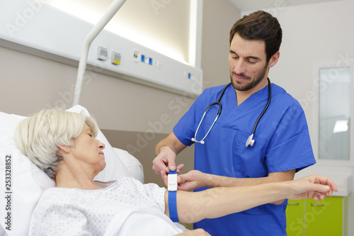 male doctor talking care of female senior patient on bed