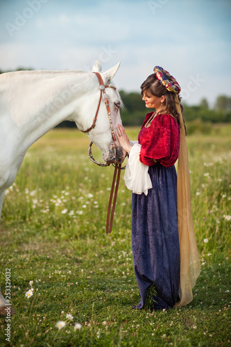 Medieval Princess with a White Horse in a Meadow