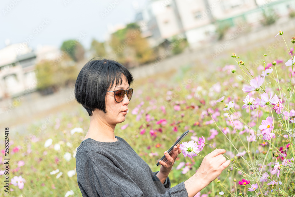 Naklejka premium woman take a picture on a flower